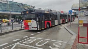 En buss vid Václav Havel-flygplatsen i Prag, Terminal 1, med passagerare i närheten.