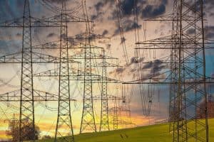 Electric power lines against a sunset sky, illustrating energy infrastructure.