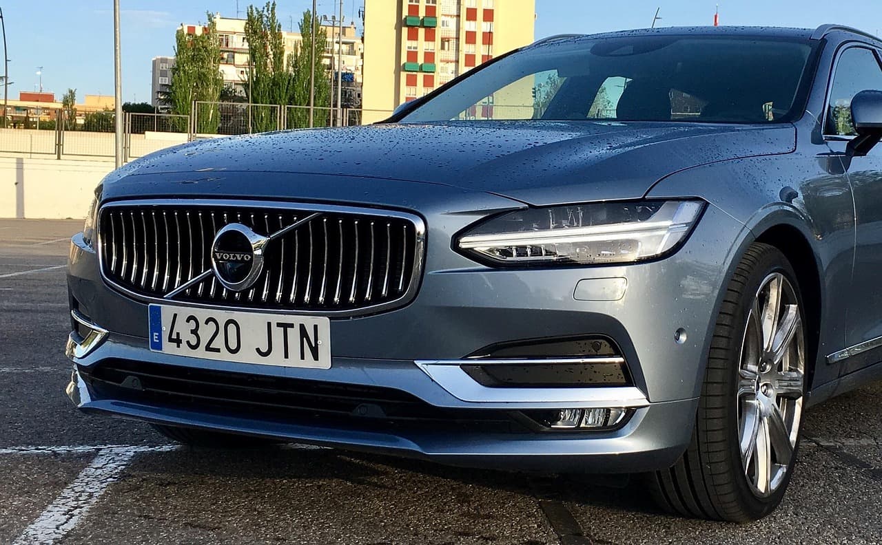 En grå Volvo bil parkerad med stadsmiljö i bakgrunden.