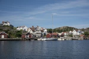 En vy av en hamn med röda och vita hus vid vattnet i Tjörn.