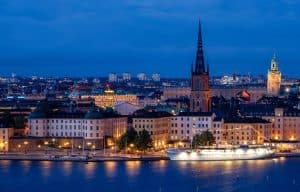 En nattvy över Stockholm med byggnader och en kajkant.