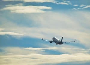 Ett passagerarflygplan som flyger på himlen med moln i bakgrunden.