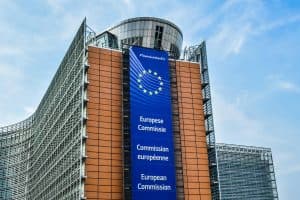 EU-kommissionens byggnad med EU-flaggan i bakgrunden.