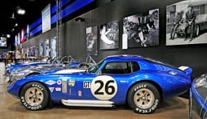 En blå Shelby Daytona Cobra Coupe utställd i en museimiljö.