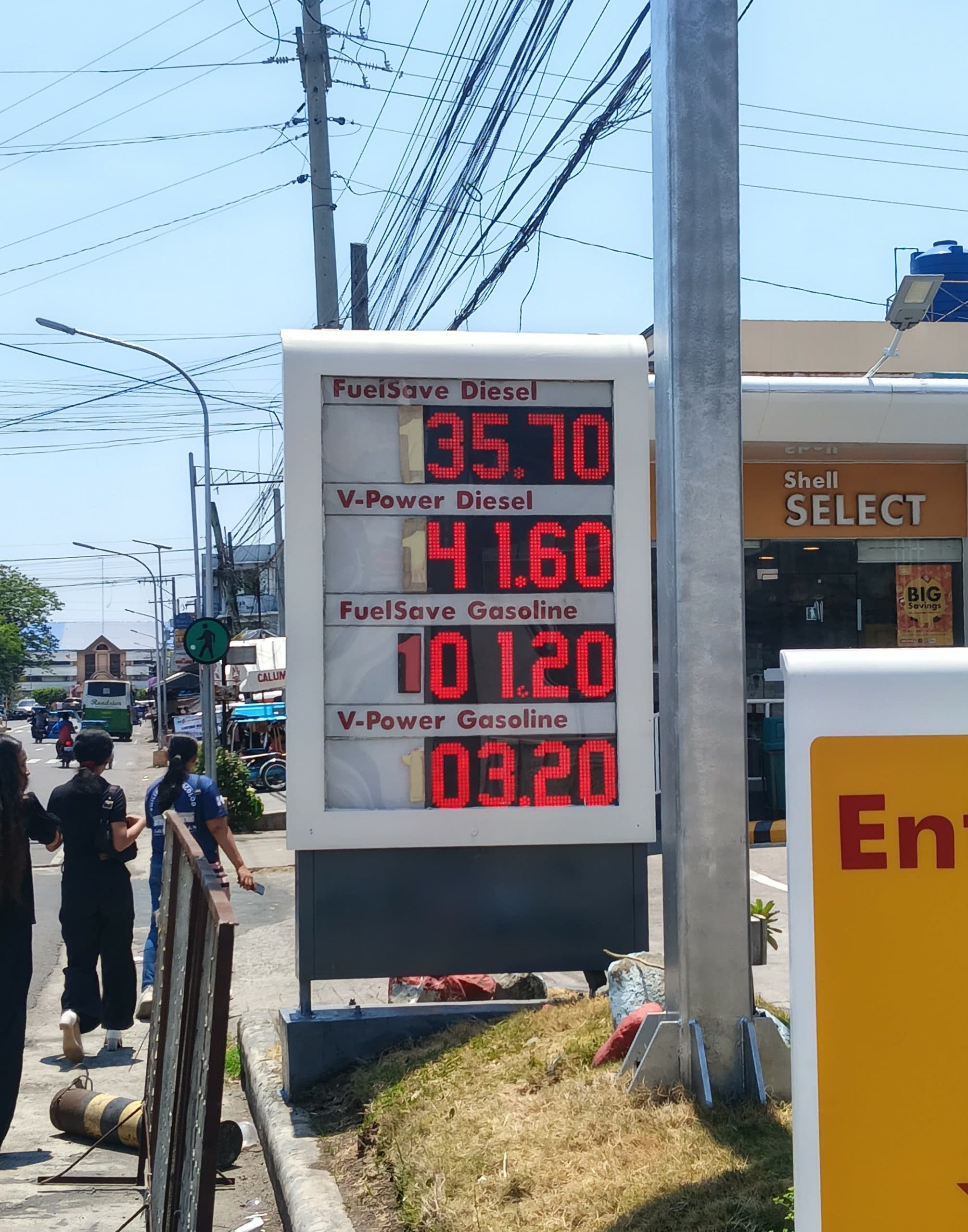 A price board displaying fuel prices for diesel and gasoline at a gas station.