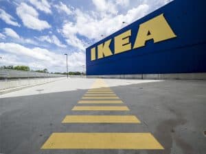 Ikea-skylt på en byggnad mot en klarblå himmel.