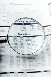 Förstoringsglas över tidningssida med aktieindex.