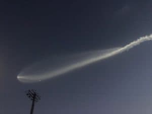 Falcon 9-raket som skjuts upp mot himlen med rök och moln.