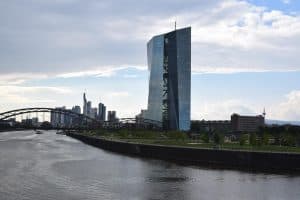 ECB-byggnaden i Frankfurt med en flod i förgrunden.