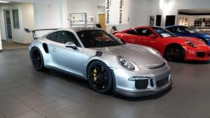 Silverfärgad Porsche-sportbil utställd i en visningshall.