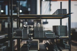 Metallprofiler staplade på industrihyllor.