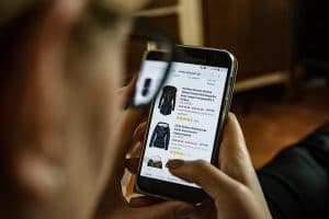 Person som håller en smartphone som visar en app för näthandel.