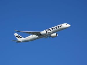 Ett flygplan från Finnair flyger i en klarblå himmel.