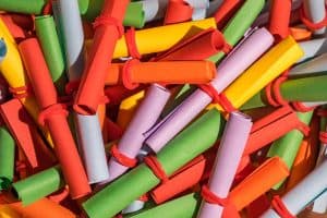 Färgglada hoprullade pappersrullar bundna med röda band.