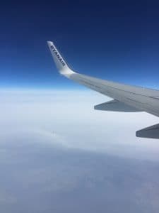 Ryanair-flygplan i luften med klar himmel i bakgrunden.