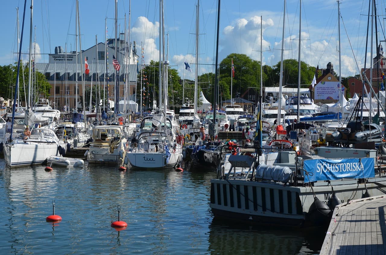 Båtar i en hamn med byggnader i bakgrunden.