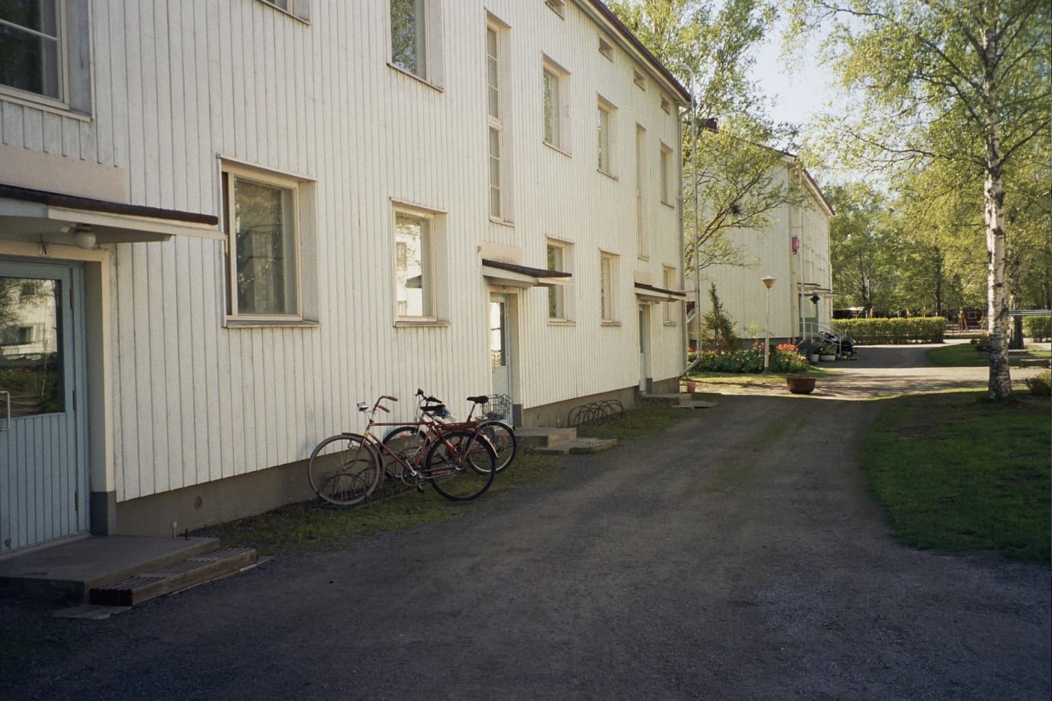 Wooden apartment buildings with bicycles parked outside.