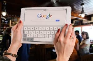 Person som håller en surfplatta med Google-sökning på skärmen.