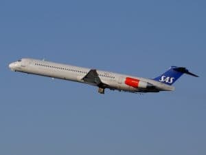 SAS flygplan i luften mot en klarblå himmel.