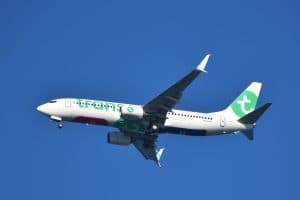Ett flygplan från Transavia flyger i klarblå himmel.