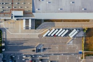 Flygbild av en stor lagerbyggnad med lastbilar parkerade utanför.