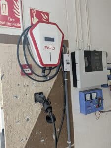 BYD-laddare för elbil monterad på en vägg i ett garage.