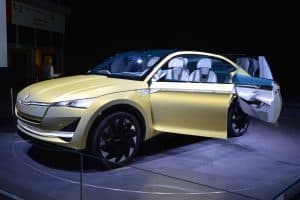 En gul Skoda Vision E elbil visas upp på en bilutställning.
