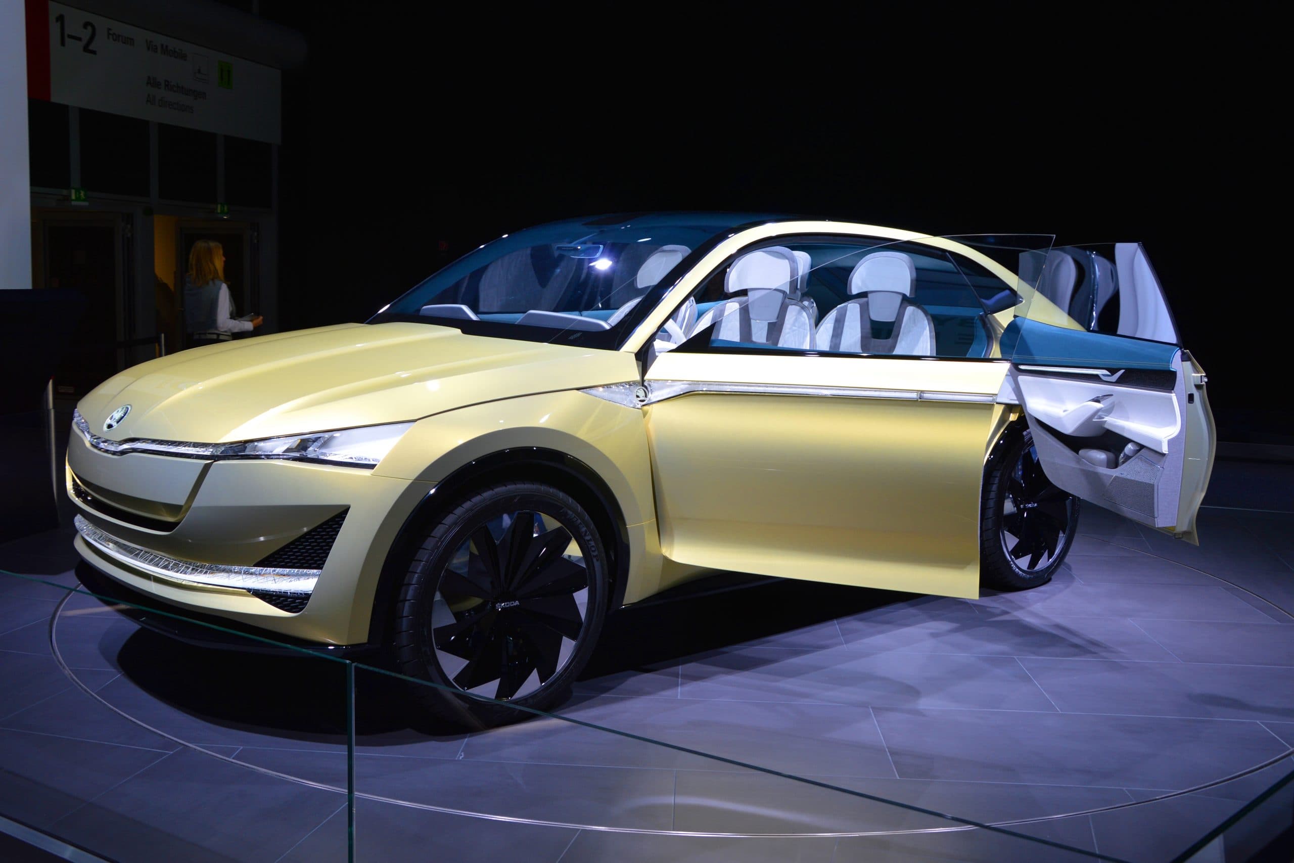 En gul Skoda Vision E elbil visas upp på en bilutställning.