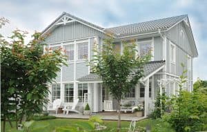 Ett stort, modernt hus med en välskött trädgård.