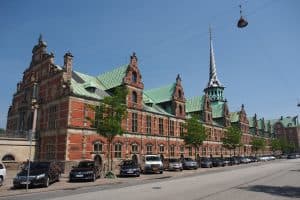 Den gamla börsbyggnaden i Köpenhamn med parkerade bilar framför.