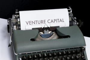 En skrivmaskin med ett papper där orden ’Venture Capital’ syns.