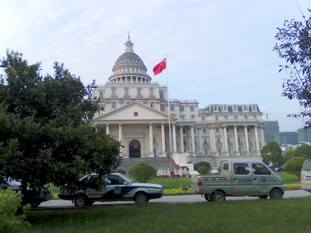 A building resembling the White House with a flag in front.