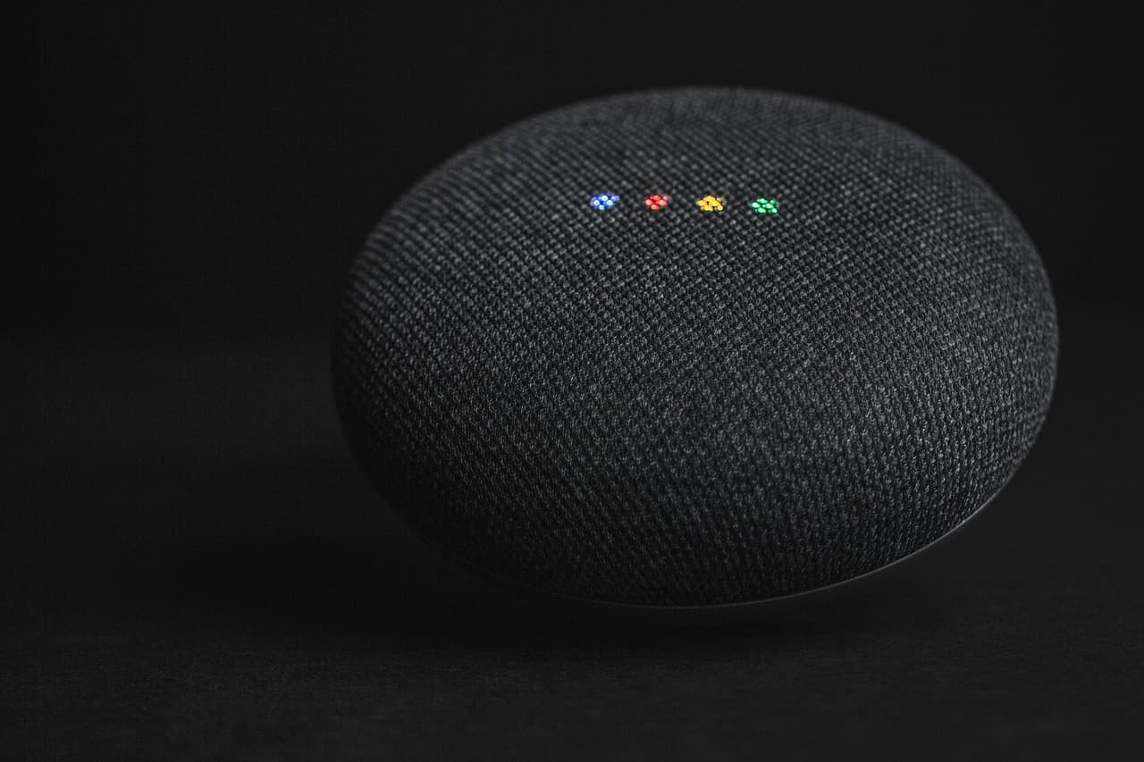 En svart Google Home-enhet på en mörk bakgrund.