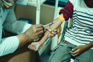En vårdpersonal som ger en injektion i en patients arm.