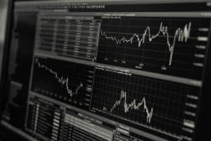 Datorskärm med flera aktiediagram och finansiell data.