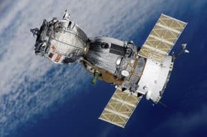 Satellit i rymden med jorden i bakgrunden.