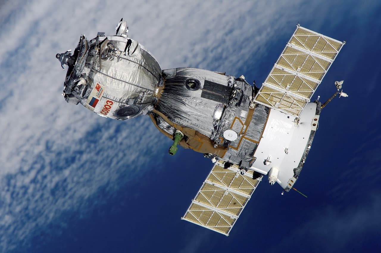 Satellit i rymden med jorden i bakgrunden.