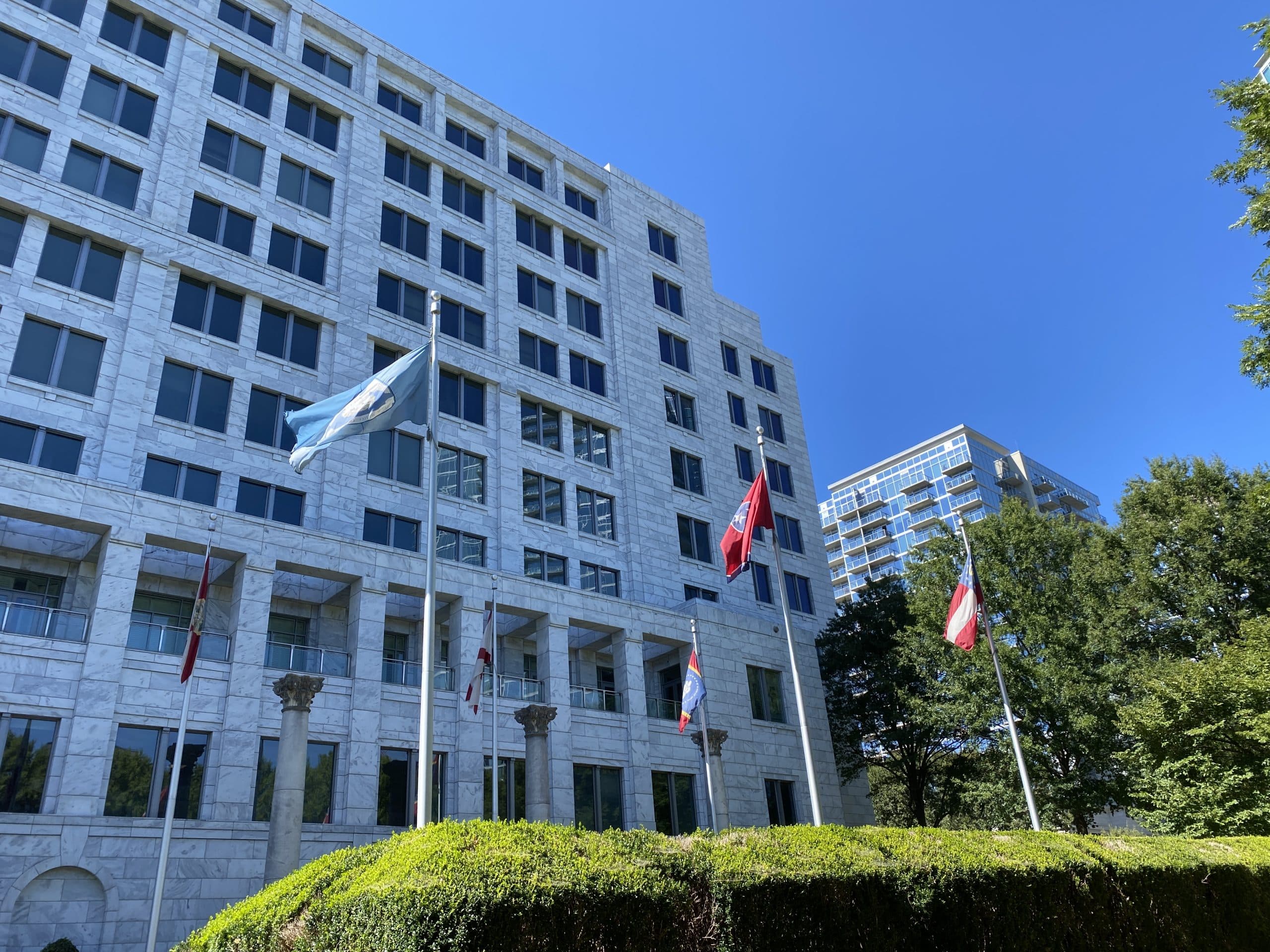 Federal Reserve Bank Building with flags and trees in front.