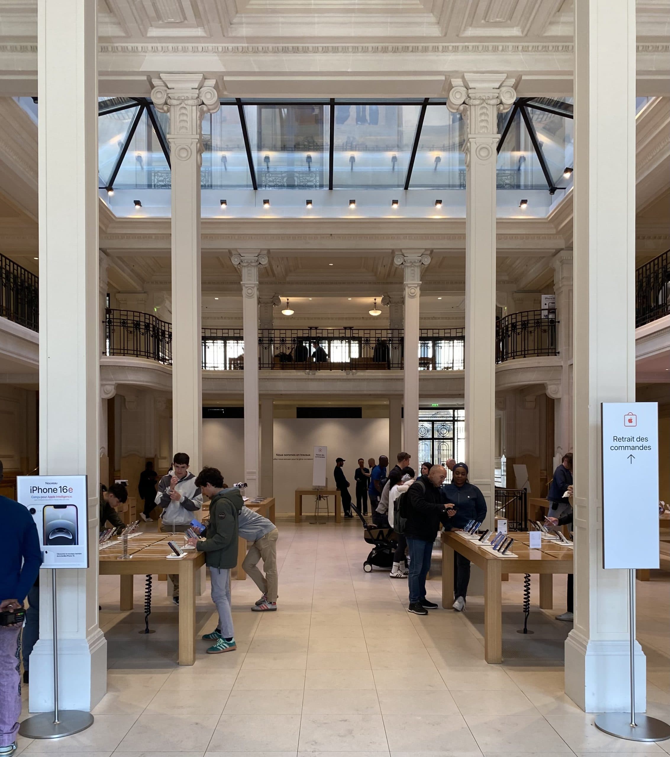 Interiör i en Apple Store med besökare som tittar på produkter.