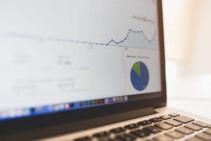 En bärbar dator med en graf över ekonomiska data på skärmen.