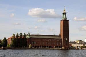 Stockholms stadshus vid vattnet under en klar himmel.