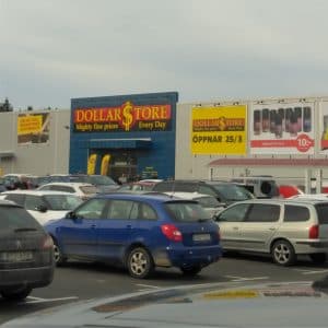 Dollarstore-butik med parkerade bilar framför.