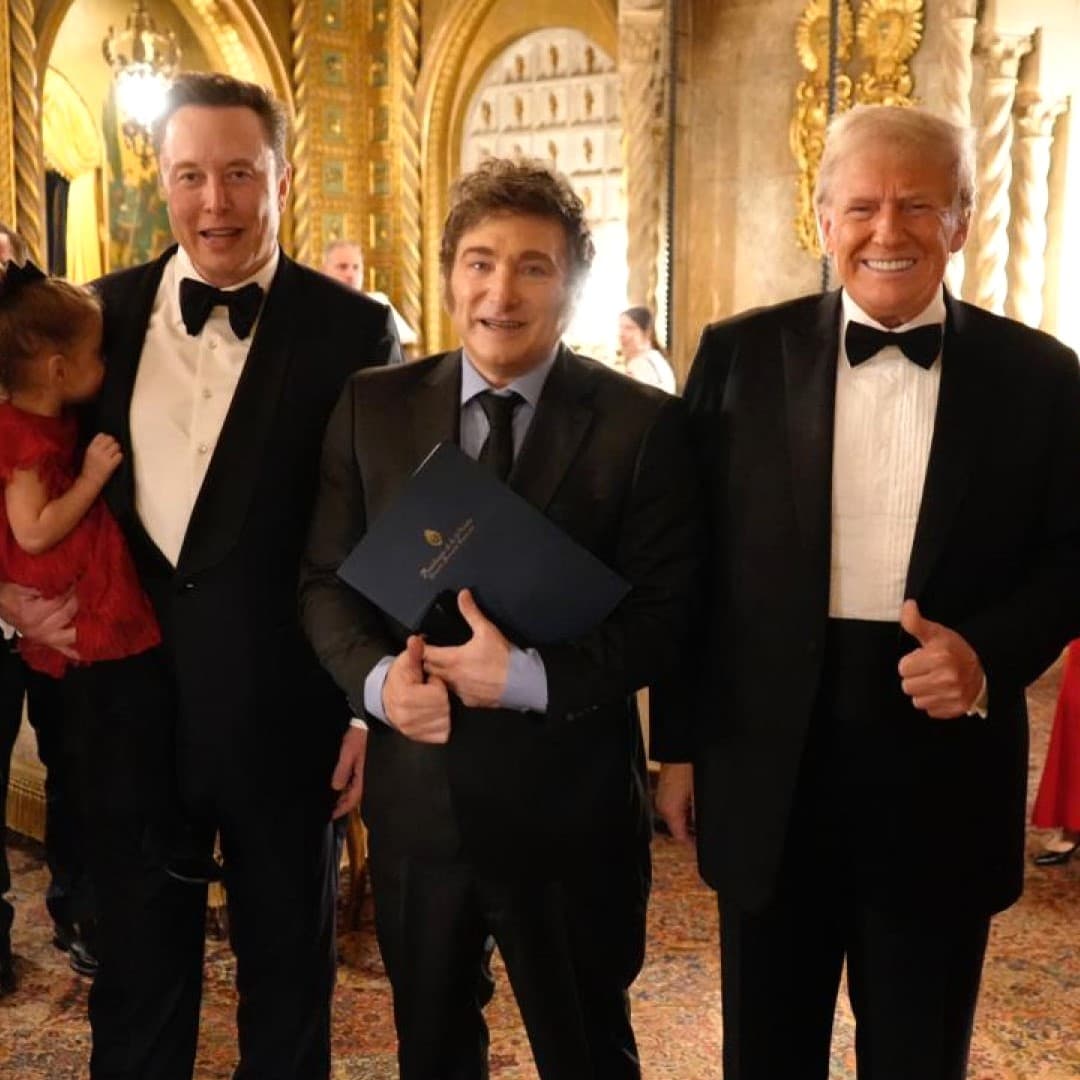 Elon Musk och Donald Trump poserar tillsammans med en annan person i en formell miljö.