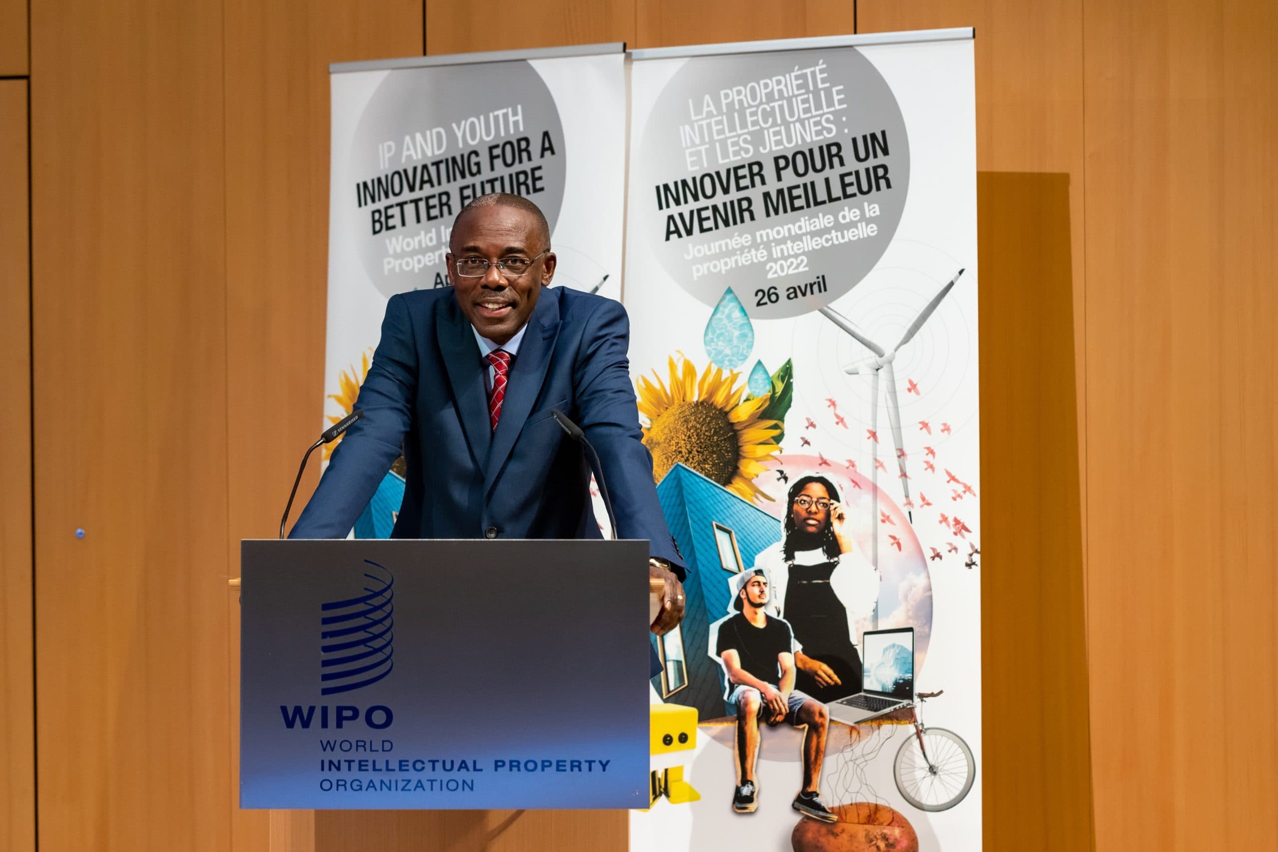 En man står vid ett podium med WIPO-logotypen och affischer i bakgrunden.