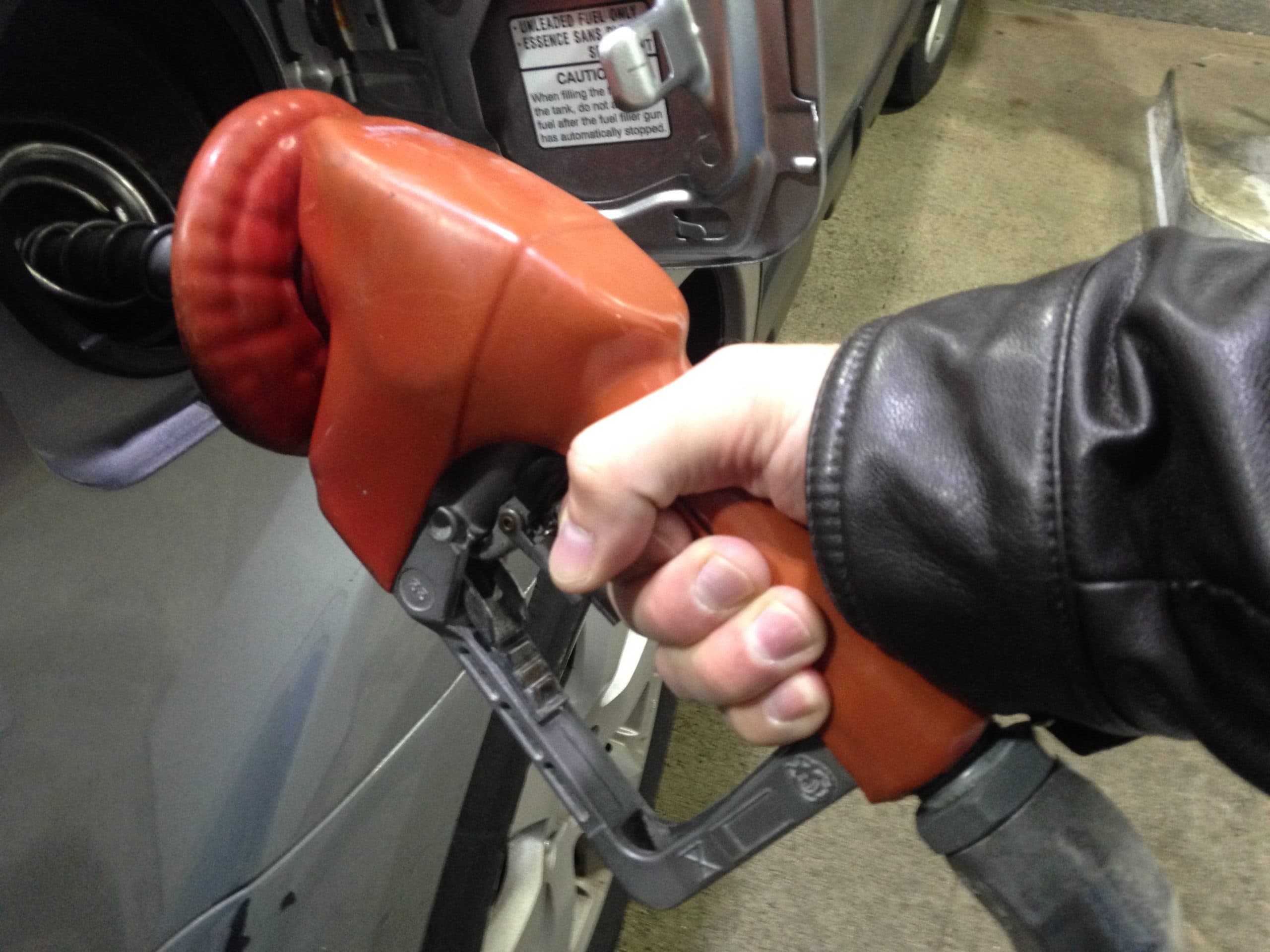 En person pumpar bensin i en bil.