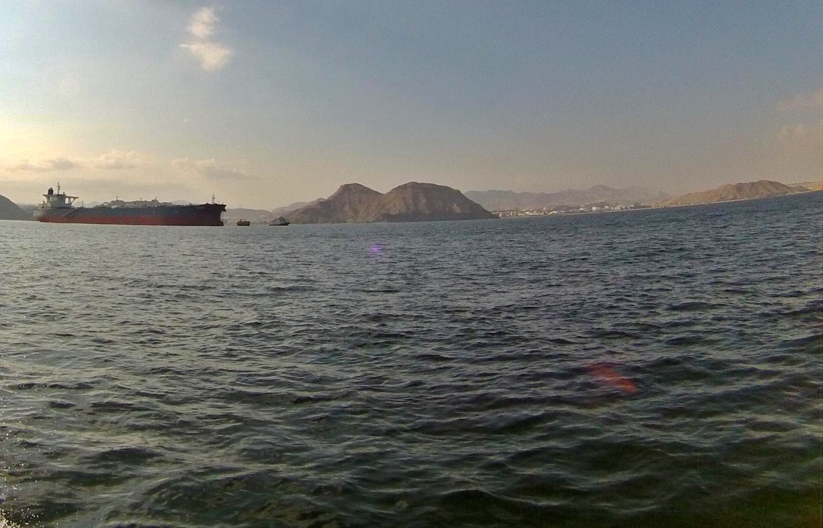 Ett fartyg på havet med berg i bakgrunden.