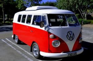 En röd och vit Volkswagen Kombi från 1966 parkerad utomhus.