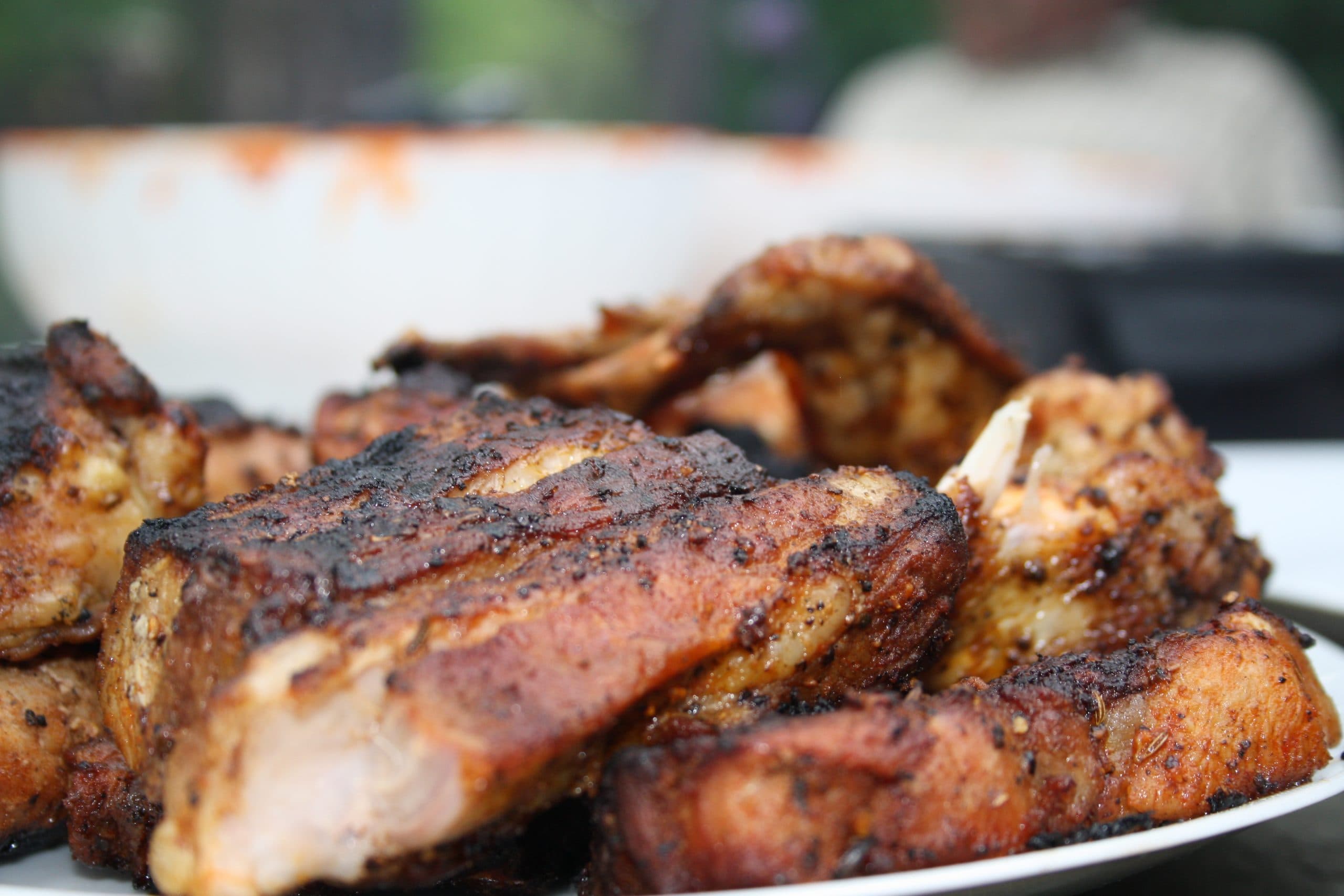 Grillade köttbitar på en tallrik utomhus.