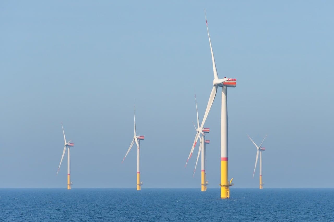 Havsbaserade vindkraftverk i havet under en klar himmel.