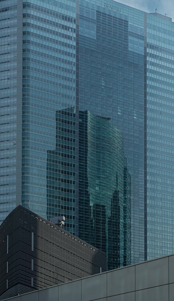 Reflektion av en modern byggnad i glasfasad.